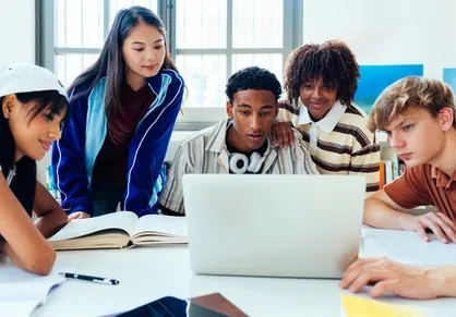 Students collaborating around a laptop
